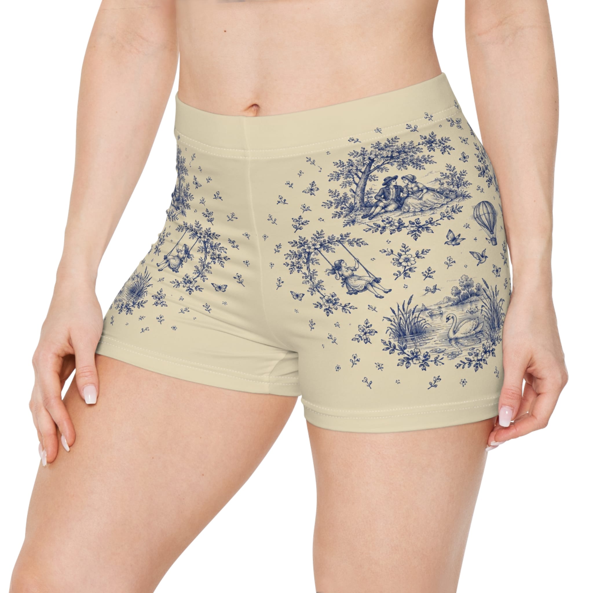 Toile print women's shorts in beige with a blue cottage and countryside pattern, shown on a model