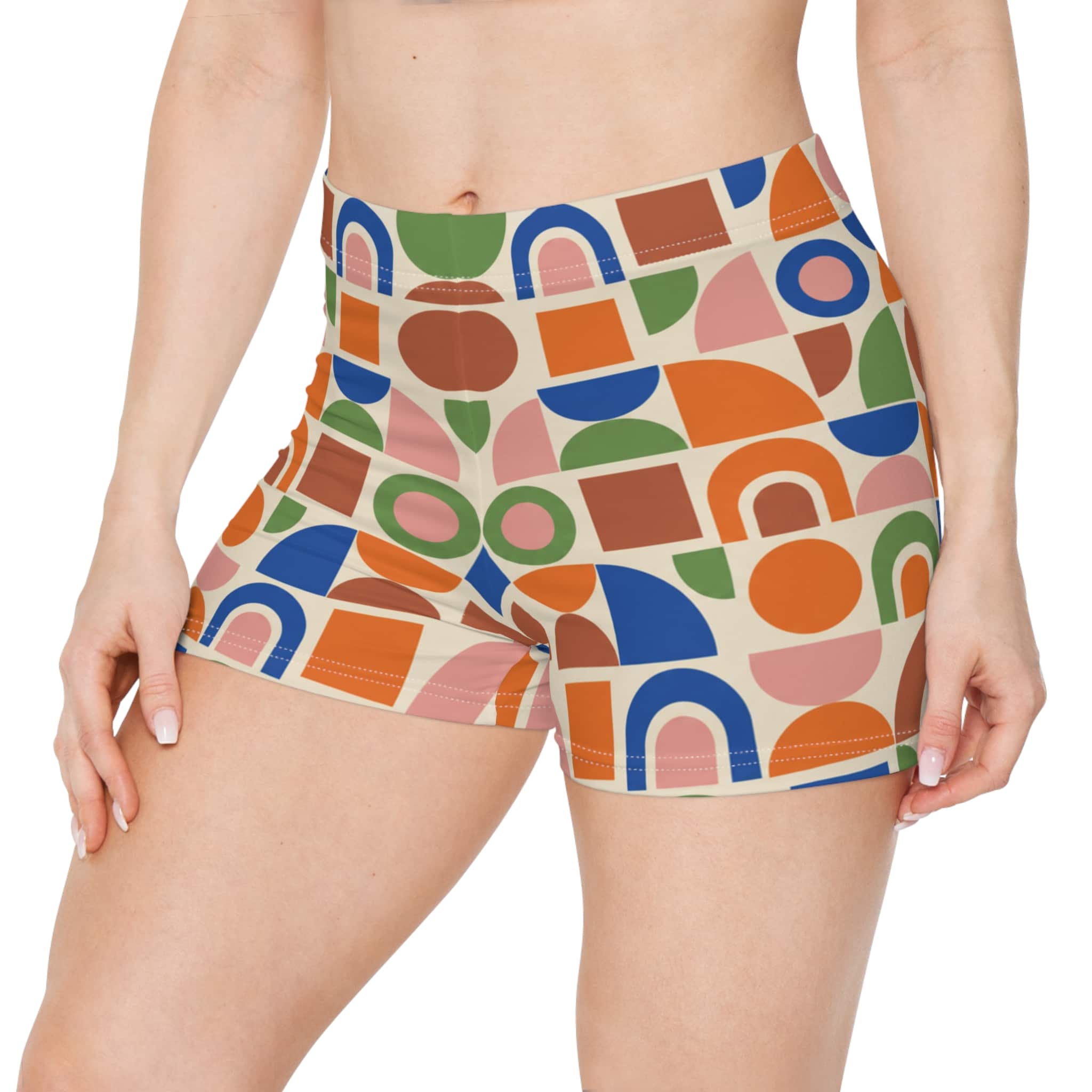 Retro geometric women's shorts with a colorful 70s mosaic pattern in orange, teal, red and cream, shown on a model