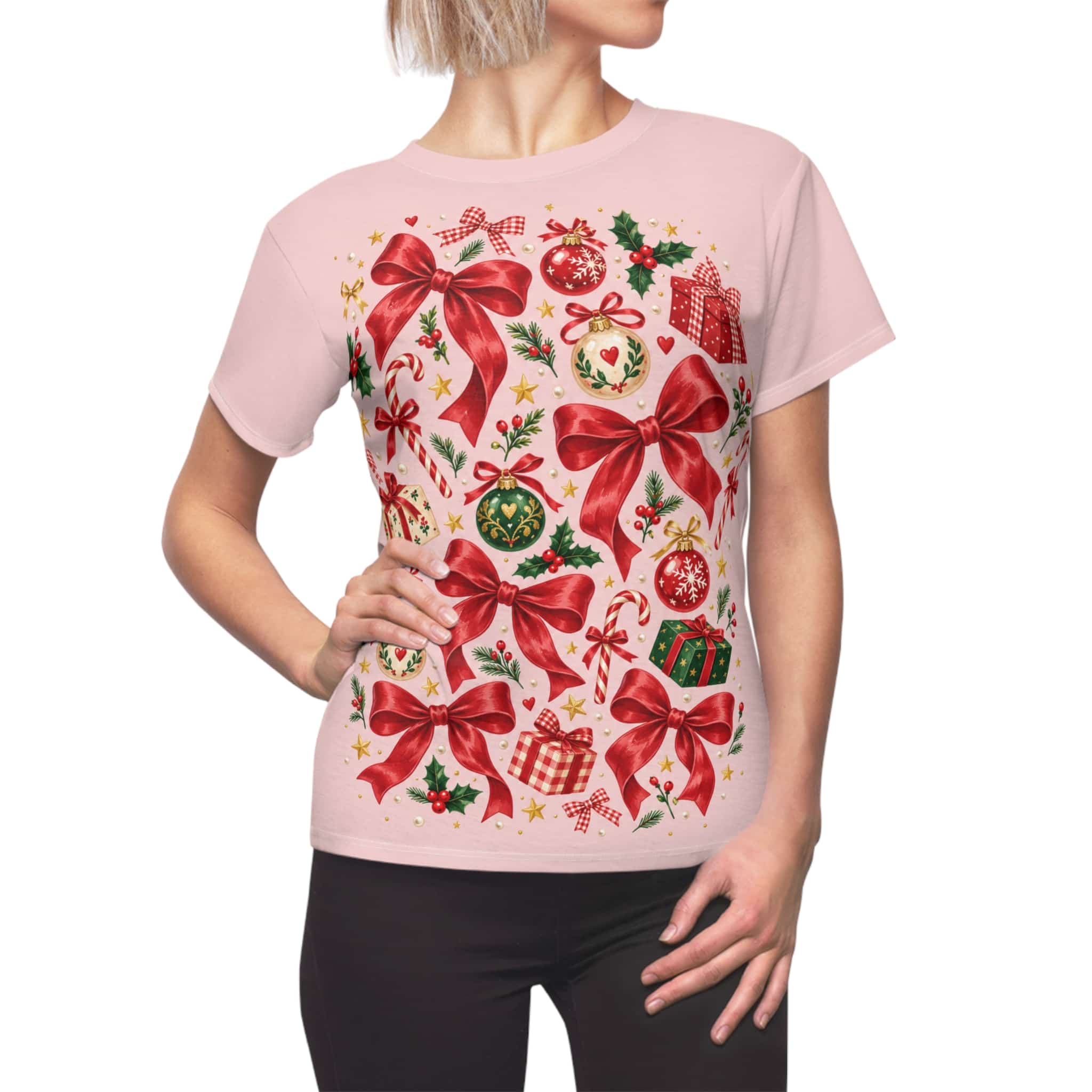 Pink women's Christmas tee with red bows and ornaments, shown on a model against a white background